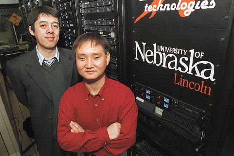 UNL Chemist Xiao Cheng Zeng, left, and graduate student Jail Bai stand next to UNL�s supercomputer PrairieFire, which helped them...