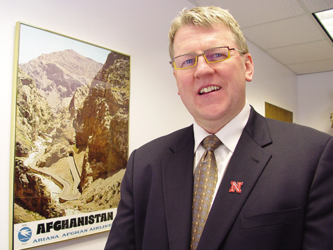 PEACE CORPS VOLUNTEER - Dave Wilson, associate vice chancellor for academic affairs, stands next to an Afghanistan poster in his office...