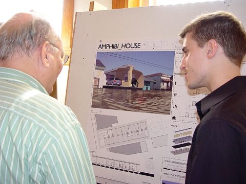 HOUSE TALK - Jason Cave (right), a senior architecture major from Omaha, discusses his Amphibi_House design with Ted Ertl, associate...