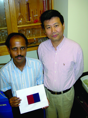 FIBER RESEARCHERS � Narenda Reddy, research assistant, holds a cloth sample made from rice straw fibers. Reddy and Yiqi Yang, professor...