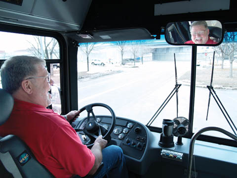 COMING AROUND - Gene Giles laughs at a stop along the garage bus route offered by Parking and Transit Services. A...