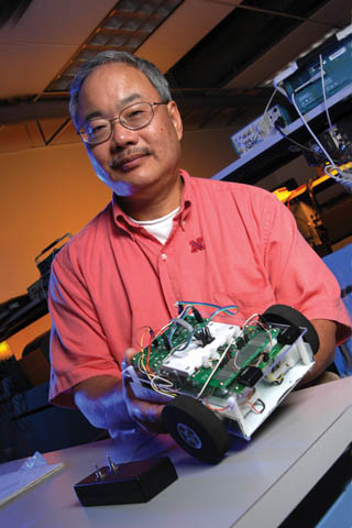 SPIRIT LEADER - Bing Chen, professor and chair of the Department of Computer and Electronics Engineering, holds a TekBot, a small...